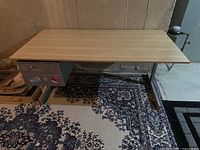 Full view of desk, laminate top, metal legs, drawers