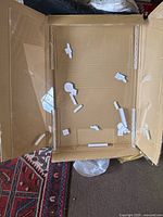 Divider inside open cardboard box, showing three clear panels and hinges