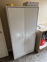 Front view of closed white storage cabinet
