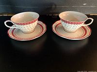 Two matching teacup and saucer sets side by side