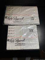 Front view of sealed sheet and pillowcase packages showing brand and trim style