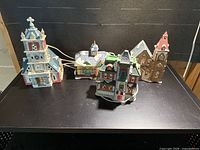 All four ceramic village buildings with cords displayed