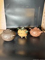 Three Chinese clay teapots side by side showing overall sizes and styles.