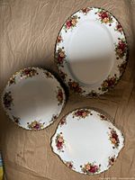 Three Royal Albert Old Country Roses plates displayed together showing different shapes and floral patterns.