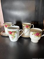 Set of four Royal Albert Old Country Roses cups with floral rose patterns and gold rims, shown with two matching plates.