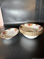 Five Royal Albert Old Country Rose bowls stacked showing floral rim and gold trim, with one bowl shown separately to the left.