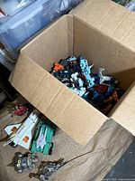 Top-down view of cardboard box filled with assorted Transformers figures