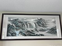 Full view of the framed Chinese landscape painting showing mountains, waterfalls, houses, and trees.