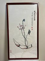 Full view of framed Chinese painting featuring lotus flowers, tall stems, and seed pods on white rice paper with Chinese calligraphy and red seal stamps to the upper right, all contained in a polished rosewood frame.