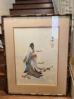 Full view of the framed Chinese painting showing the woman in colorful traditional clothing, bamboo-style wood frame, and matting.