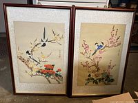 Full view of two framed Chinese paintings with birds and flowers, showing overall condition and framing.
