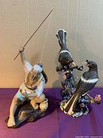 Photo showing two ceramic figurines: a fisherman holding a fishing rod on the left, and a birds figurine on the right.