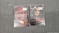 Photo showing two sealed DVD cases of The Handmaid's Tale Seasons 1 and 2 side by side on a grey surface.