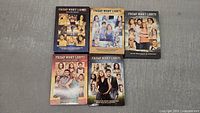 Five DVD box sets of Friday Night Lights complete series seasons 1-5, arranged in two rows. Box cover art visible showing cast and season info.