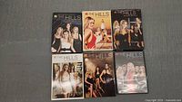 Photo showing six DVD box sets of The Hills Seasons 1 to 6 arranged in two rows of three. Each season features distinct cover art with cast members pictured.