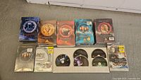 9 Stargate DVD box sets arranged with some open and some sealed, showing discs and cover art.