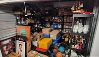 Front view of storage unit contents with shelves of DVDs, boxes, bins, toys and dishware