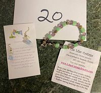 Photo showing the bracelet, angel earrings cards, and Lilac Cottage jewelry card with care instructions and contact info