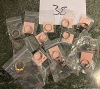 Top view of 13 individually bagged rings of different sizes labeled with size tags on a flat surface.