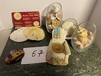 Overview of assortment showing sea shells, decorative painted shell, wooden chair candle holder, and Florida sand dollar card.