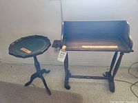 Front view of the vintage wooden book trough with slide-out trays and the small round table beside it on the left, showing overall form and proportion.