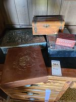 Overview of five boxes showing different materials and designs on wooden surface