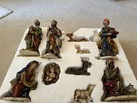 Overview of all ceramic nativity figurines in original styrofoam packaging, including Mary, baby Jesus, three wise men, shepherd, and animals.