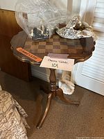 Full view of round wooden table with chessboard top and plastic bags containing chess pieces on table surface.