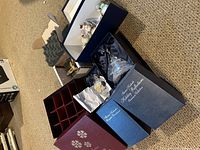 Photo showing open boxes containing Danbury Mint ornaments, including the two Thomas Kinkaid glass bell ornaments in blue boxes with 'Holiday Reflections' text visible.