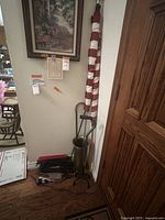 Photo showing two folded American flags next to a brass umbrella stand containing several compact umbrellas and canes