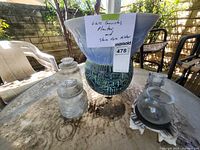 Photo of the glass canisters, planter and stone vase holder on outdoor table