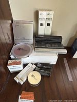 Grouped assortment of boxed iT Cosmetics makeup including foundations, powders, and mascaras.