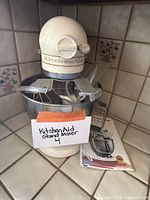 KitchenAid stand mixer with stainless steel bowl, attached paddle, and a splash guard installed, along with a note stating 'KitchenAid Stand Mixer 4'