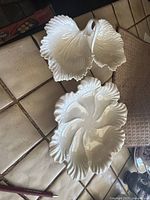 Two Lenox white porcelain serving pieces, one a multi-section divided dish and one a two-section handled piece, shown from above on a tile floor.