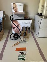 Full view of Luminess Air Airbrush Makeup System components including airbrush gun, hose, foundation bottles, and box
