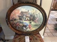 Full view of the oval framed art print showing the painted English garden with cottage and flowers.