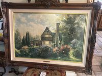 Full view of the framed print depicting an English countryside home with blooming garden under blue sky with clouds.