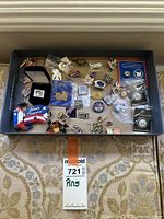 Photo overview of a tray with various colorful enamel pins including Texas, Olympics and USA themes, showing condition and quantity.
