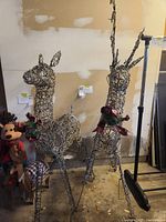 Two large woven wire reindeer yard decorations, one taller with antlers and one smaller without.