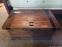 Closed trunk made of solid wood with metal reinforcements on corners and latch on front