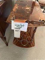 Front view showing drop-leaf side, turned wood handle, paper label and six-bottle metal rack on lower tier.