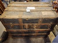Top view of trunk closed showing metal hinges, latches, and worn black paint with rust spots on metal parts.