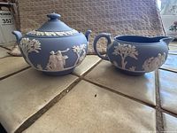 Front view of the Wedgwood cream and sugar set showing the blue jasperware and white classical relief designs.