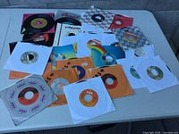Overview of approximately 30 45 RPM records on table