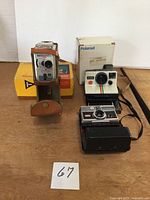 Group shot showing all three cameras, leather case and two original boxes