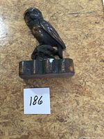 Front view of cast copper owl door stop on scalloped base