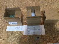 Overview of three cardboard boxes filled with trading cards on work surface