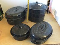 Group shot showing all four enamel cookware pieces with lids