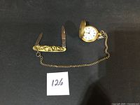 Pocket watch and knife laid flat for overall view