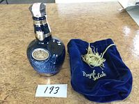 Front view of blue Royal Salute porcelain bottle and velvet pouch